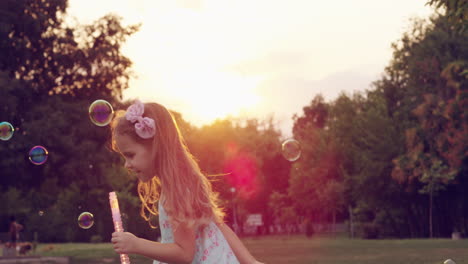 little girl playing with bubbles in