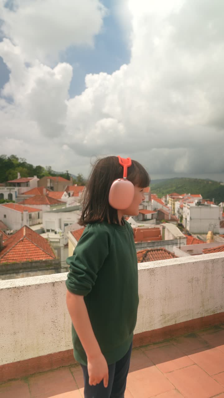 Girl with headphones on rooftop in a city