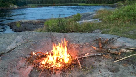 escudo boreal canadiense fuego de campamento en la roca cerca del turbulento río berens norte de manitoba canadá