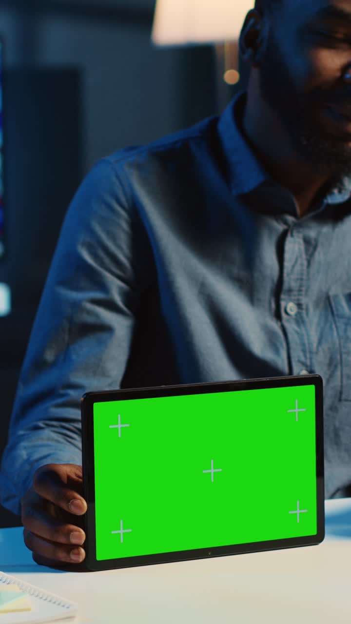 Video verticale di un influencer che filma un tablet con green screen