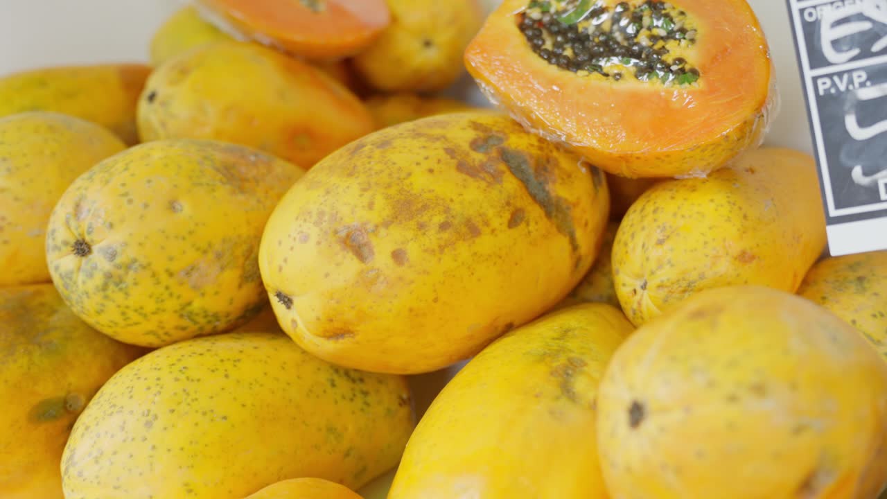escena del supermercado español: lujosas papayas, mostrando su vibrante interior