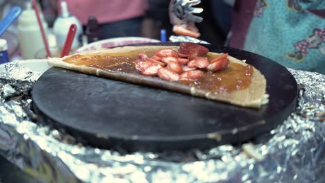 Adding-chopped-strawberry-on-the-crepe