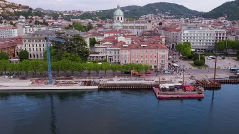 Vista-De-Drones-A-Orillas-Del-Lago-De-Como-Italia-De-Las-Defensas-De-Agua-De-La-Barrera-Y-El-Sitio-De-Construcción-De-La-Pasarela---Inclinándose-Hacia-Arriba-Para-Establecer-El-Disparo