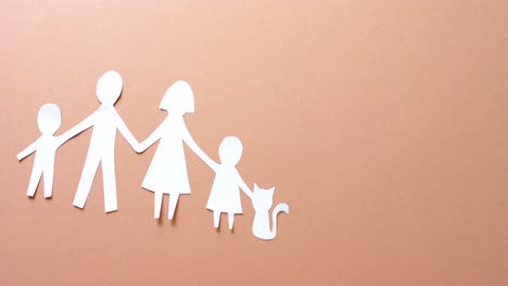 close up of family with cat made of white paper on beige background with copy space