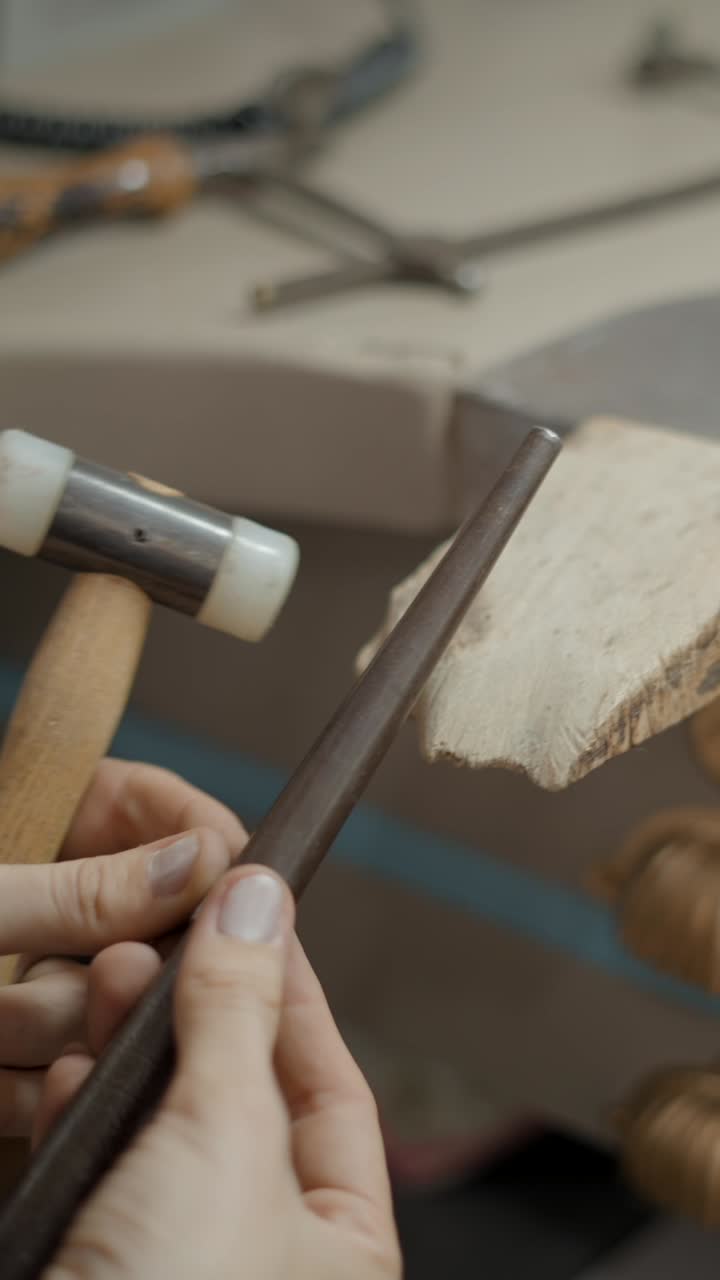 Artisan at work: Shaping metal with hammer and mandrel for jewelry making
