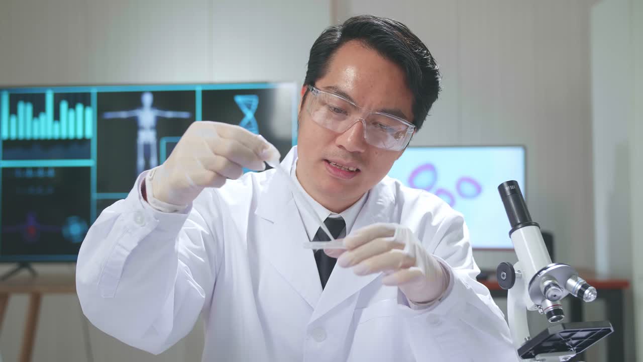 Asian Scientist Researching In The Laboratory With A Microscope And Speaking To The Camera