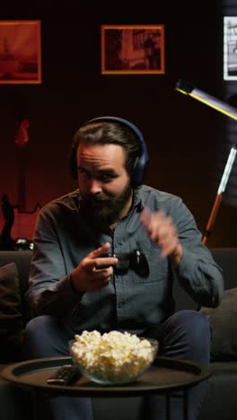 vertical video smiling man putting headphones on to play videogames with teammates