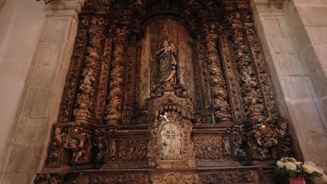 elaborate baroque altar with statue and floral carvings inside church