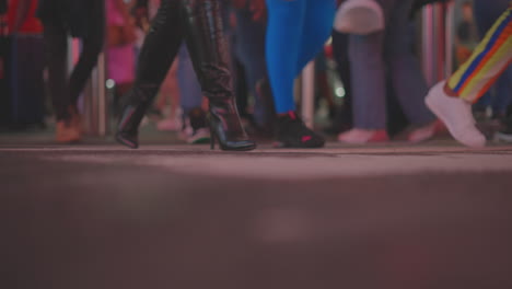 personas caminando por una calle de la ciudad por la noche