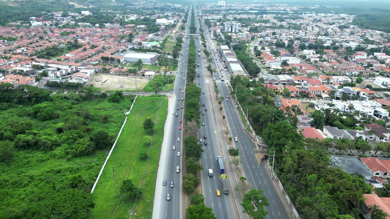 Aerial footage of Via a la Costa, Ecuador. Showcases the highway, residential areas, and lush landscapes. Perfect for travel, real estate, and urban planning visuals.