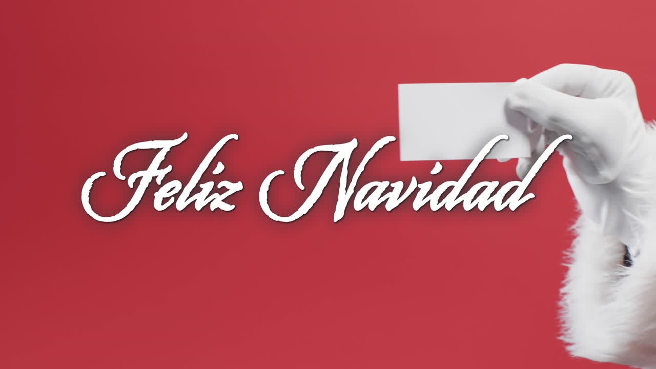 feliz navidad texto en blanco sobre la mano de papá noel sosteniendo una tarjeta en blanco sobre fondo rojo