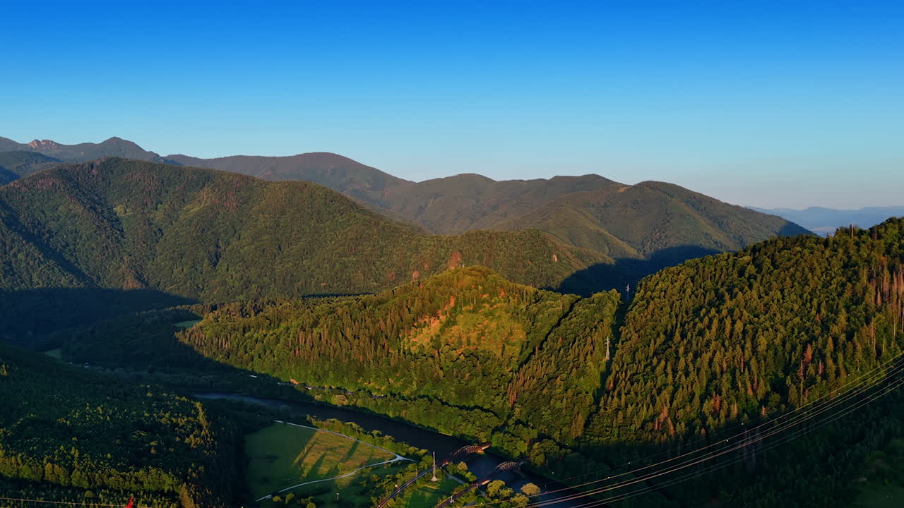 Stunning mountains and blue sky. Green mountains rise with a winding river below, showcasing nature's stunning beauty