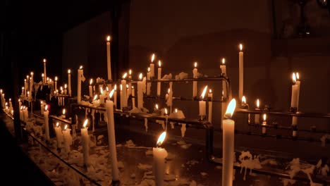 soft flickering church candles glowing, warm light in a dark environment