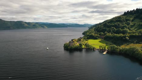 Tapiz-Aéreo-De-Las-Tierras-Altas:-Castillo-De-Urquhart-En-Medio-De-La-Exuberante-Vegetación-De-Escocia-En-El-Lago-Ness,-Inverness