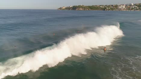 Toma-Aérea-De-Una-Gran-Ola-De-Tubo-Y-Un-Sufridor-En-Playa-Zicatela-Puerto-Escondido,-Oaxaca