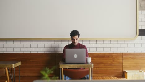 hombre trabajando en una computadora portátil en una cafetería