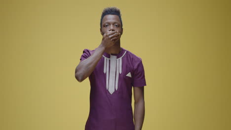 young man covering his mouth, gesturing silence or secrecy