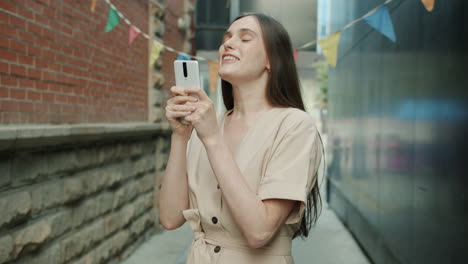 young woman using smartphone in urban alley