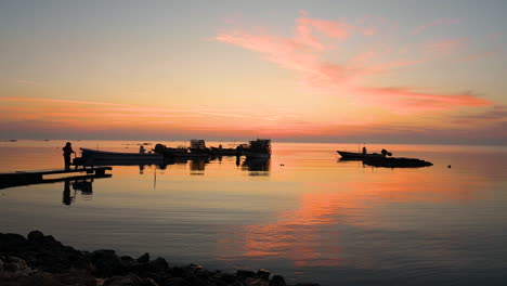 silhouette fisherman worker pulling fish traps on boat to the pier over beautiful colorful calm water waves and sky clouds background, bahrain