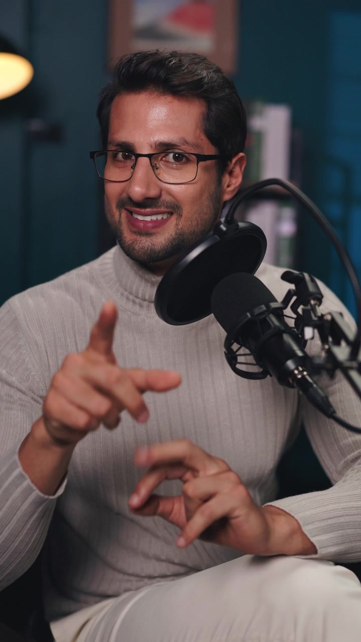 Giovane uomo che parla al microfono in un ambiente di studio professionale.