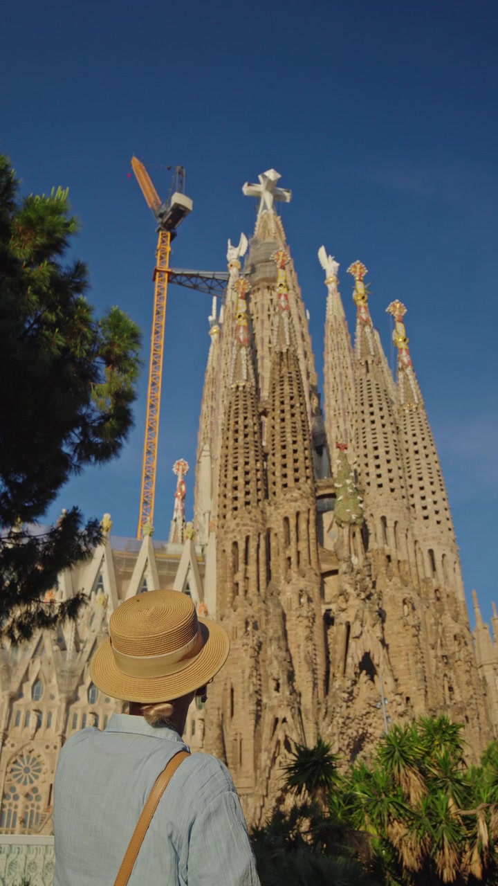 Turista donna fotografa la Sagrada Familia a Barcellona con lo smartphone