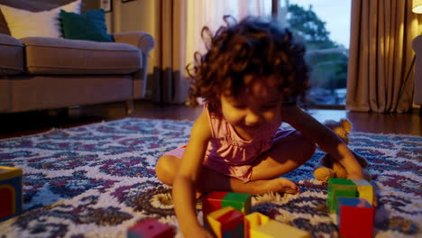 happy little girl playing with blocks at home