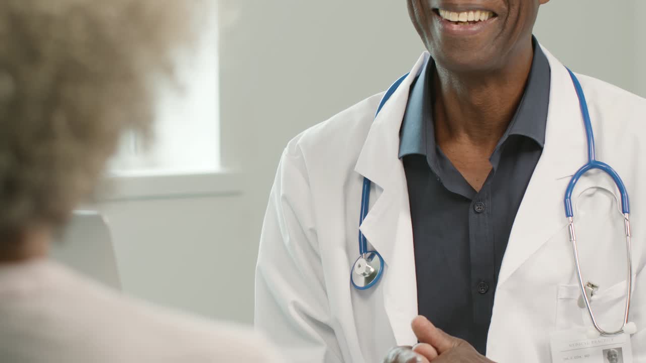 sección intermedia doctor sonriente hablando con el paciente