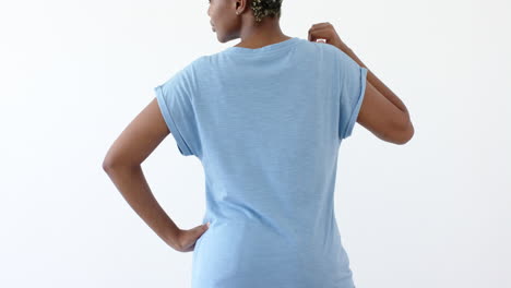 mujer afroamericana vistiendo una camiseta azul con espacio de copia en un fondo blanco