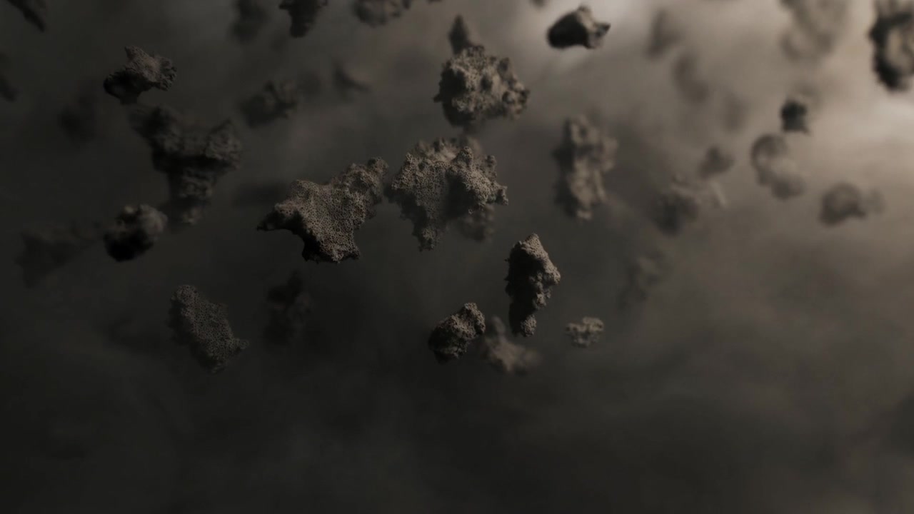 Drifting cluster of rock fragments moving toward camera as debris entering, lit upper-right