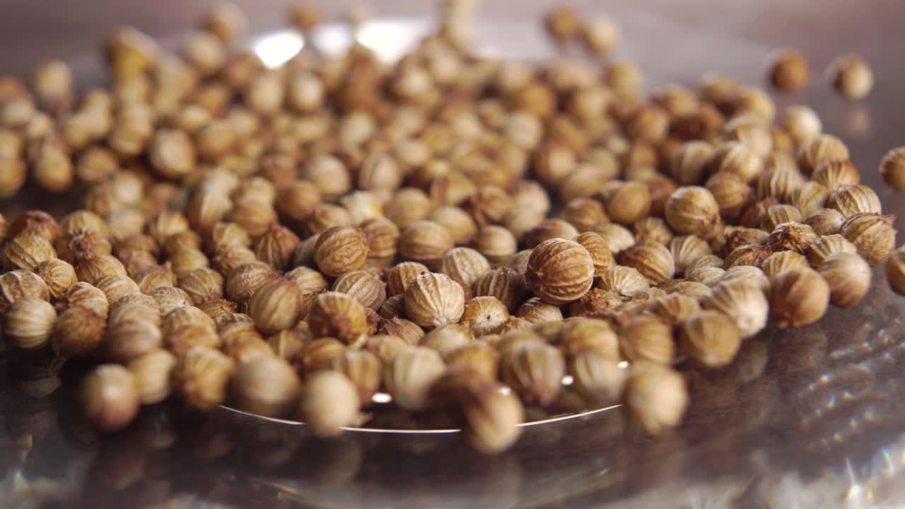 乾燥したコリアンダーやコリアントロの種子を光沢のある皿にけスパイスハーブの調味料マクロ