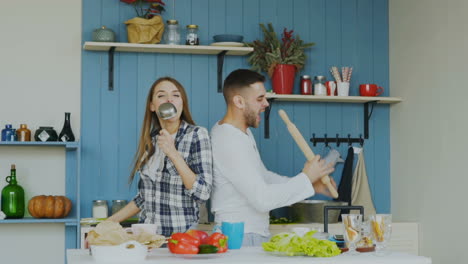 pareja cantando y bailando en la cocina