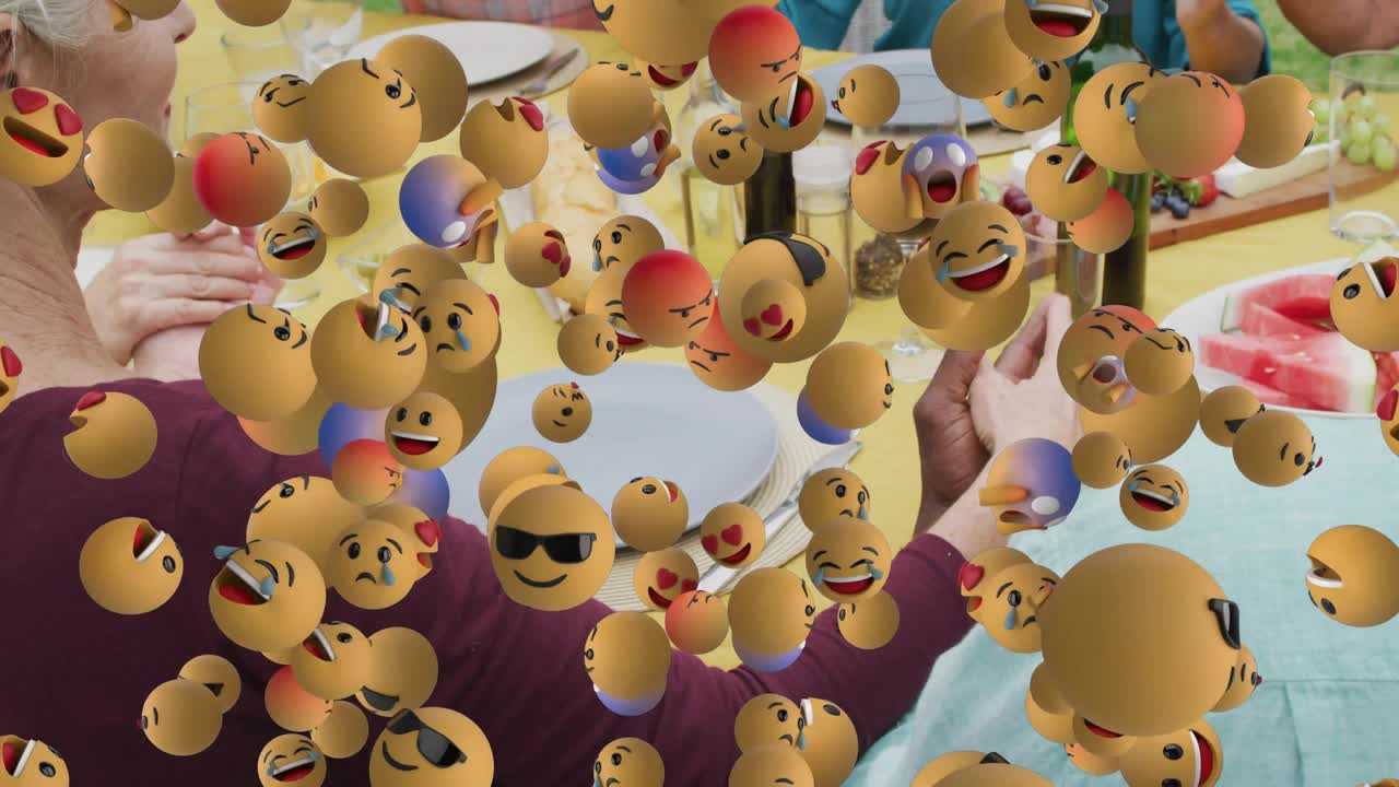 Group clapping at garden patio table causing swirling emoji cloud highlighting food marketing