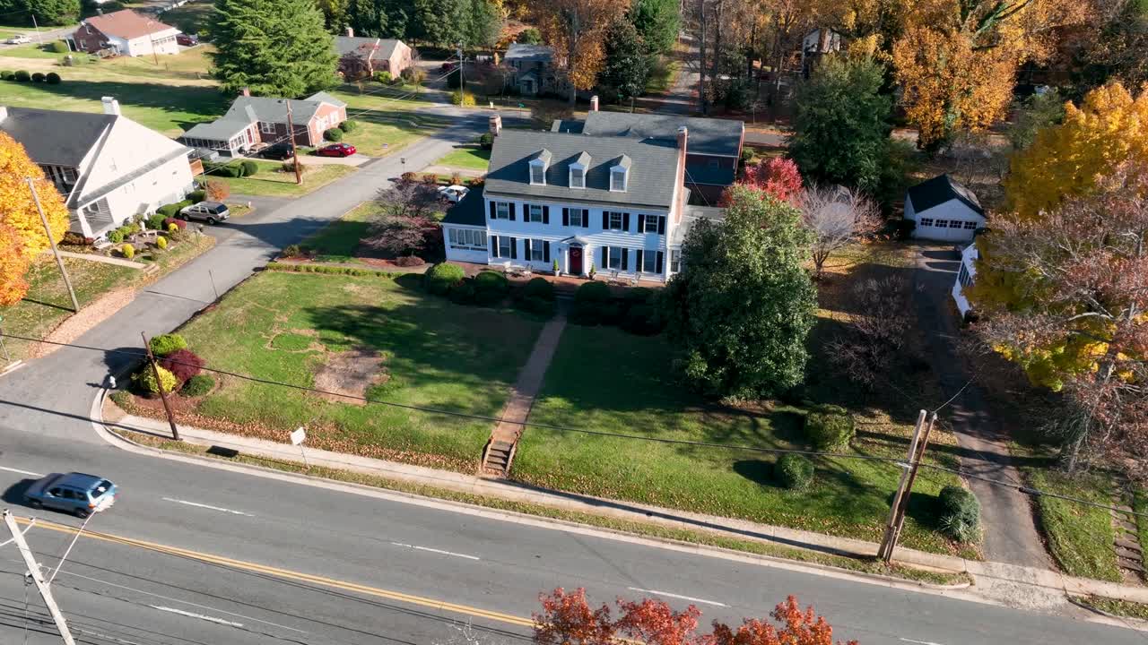gran casa blanca con persianas y ventanas abuhardilladas