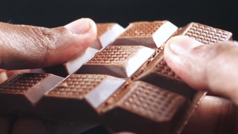 rompiendo una deliciosa barra de chocolate con nueces