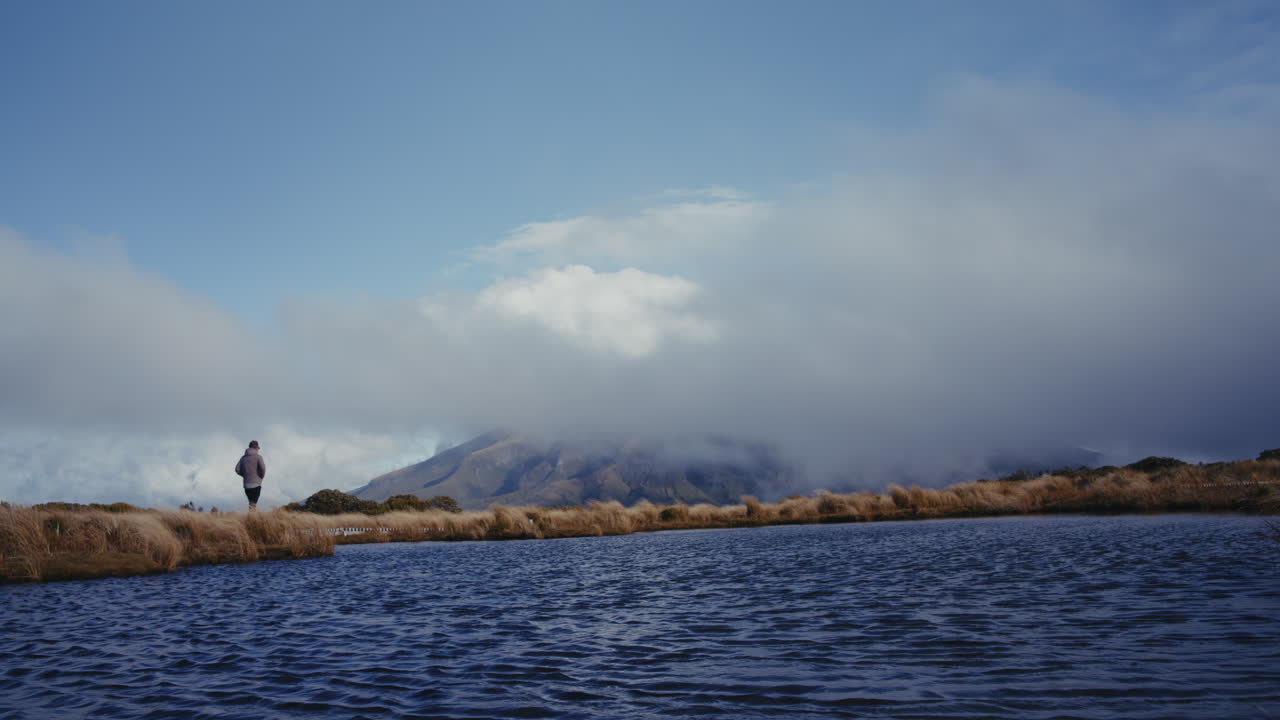 Person Hiking by a Mountain Lake