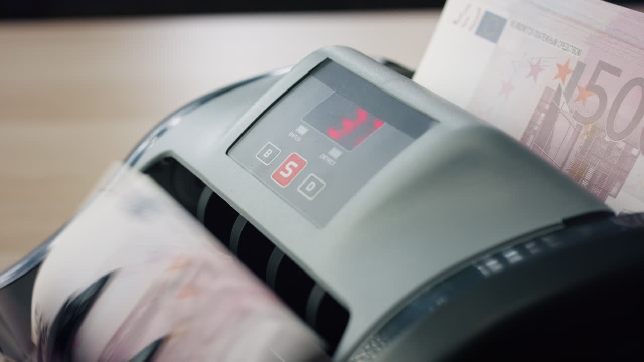 Bank automatic equipment counting paper bills european currency close up.