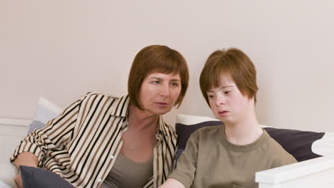 young girl and woman talking on the sofa at home