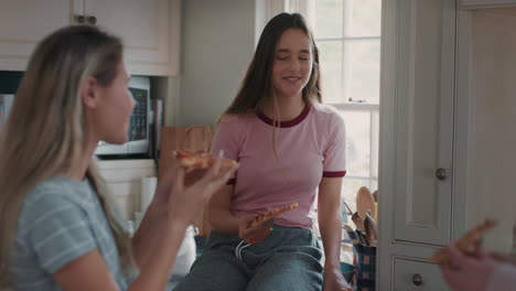 Un-Grupo-De-Chicas-Adolescentes-Comiendo-Pizza-En-La-Cocina-Divirtiéndose-Charlando-Juntas-Compartiendo-Chismes-Con-Amigos-Disfrutando-Relajándose-En-Casa