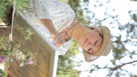 beautiful and talented artist paints a picture on an easel