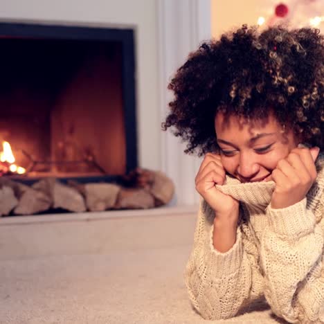 woman by fireplace and wearing warm sweater