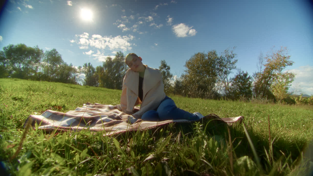 Woman Relaxing on a Picnic Blanket in a Park