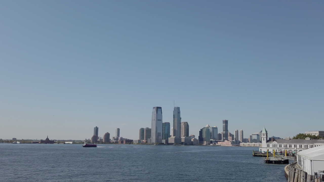 Filmagens grande-angulares do distrito do Brooklyn com o horizonte de Manhattan no plano de fundo do lado oposto. O oceano refletindo a cidade durante o dia