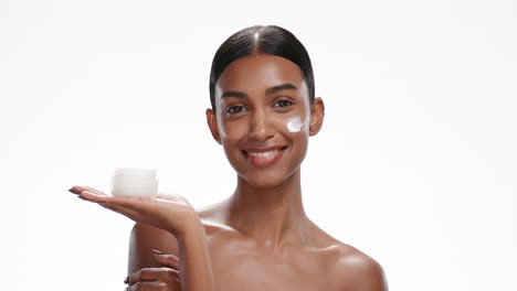 rostro de mujer india aplicar crema para el cuidado de la piel