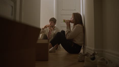 una pareja comiendo sándwiches durante la mudanza.