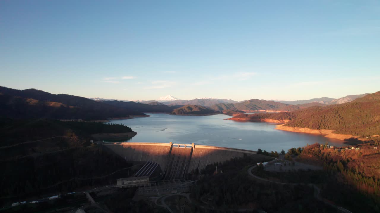 tiro al atardecer del hermoso lago con presa, montañas