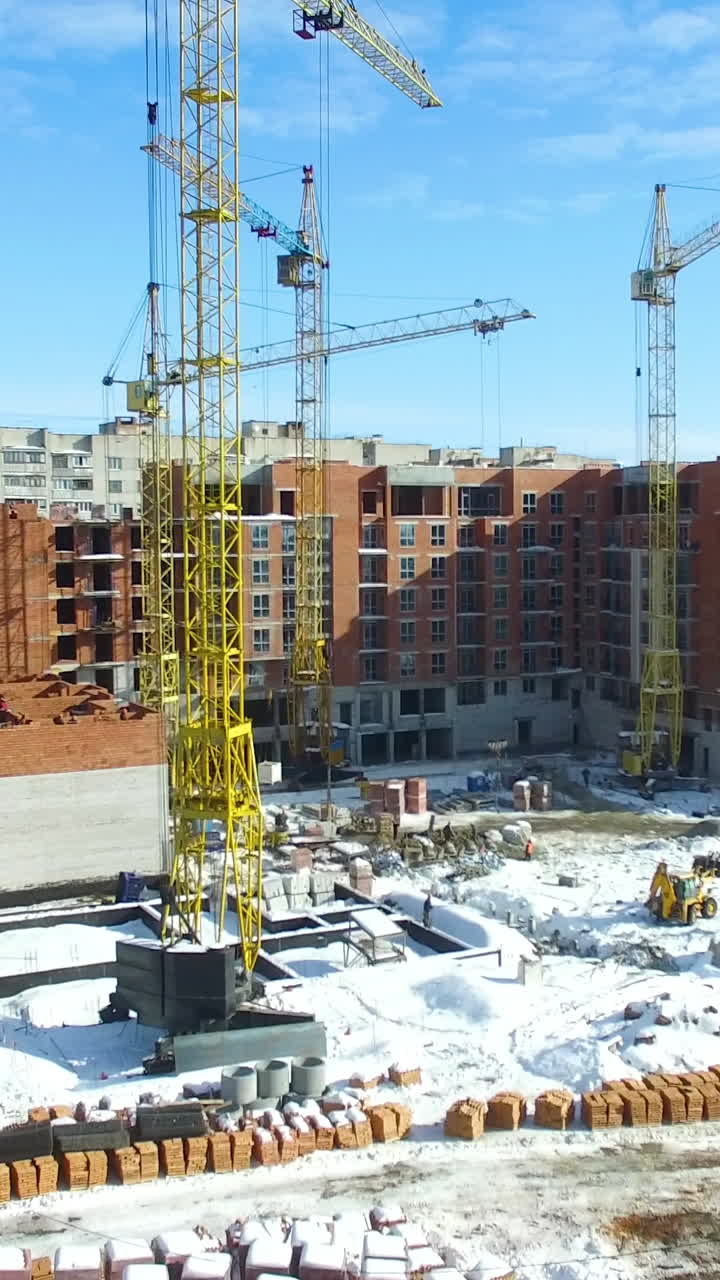 New house construction. Large apartment buildings construction in new district among houses