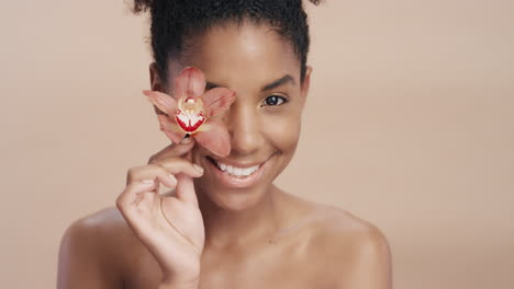 close up beauty portrait attractive african american woman touching body with orchid flower caressing healthy skin complexion enjoying gentle fragrance of natural essence skincare concept