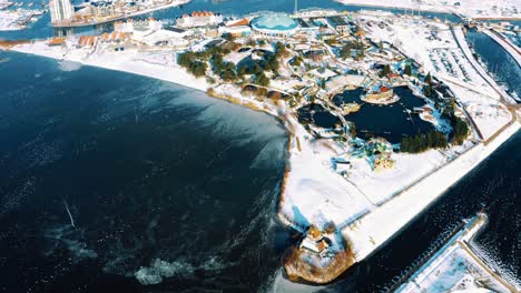 harderwijk, netherlands, aerial drone view above icy frozen port canal, snowy town landscape, europe, day, tilt down