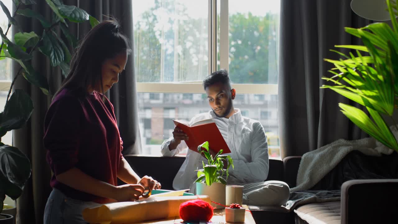 집 4k의 거실에서 선물을 포장하는 젊은 아시아 여성의 측면 뷰
