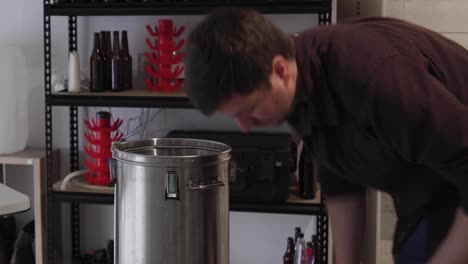 Placing-false-bottom-and-mash-tun-into-brewing-kettle-in-garage-home-brewery